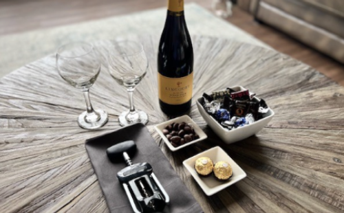 Bottle of wine with two wine glasses next to chocolate