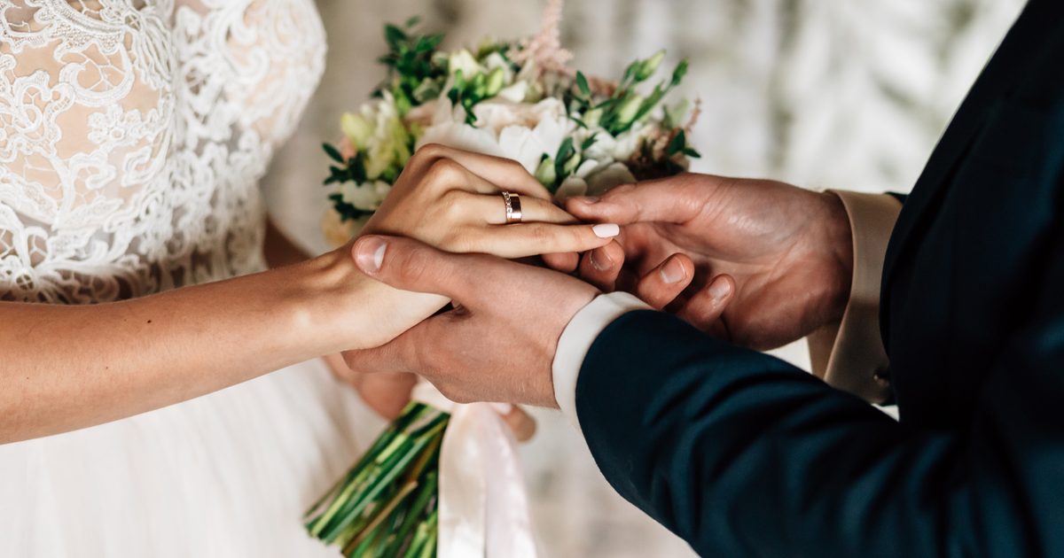 Close up of bride and groom exchanging rings